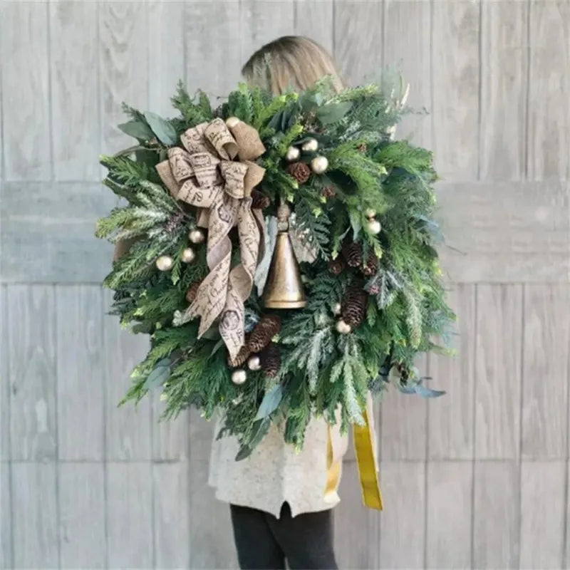 Kerstkrans voor de deur met dennenappels en jute strik